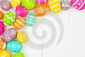 Colorful Easter Egg corner border over a white wood background