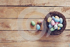 Colorful Easter egg and nest on wooden table background with copy space