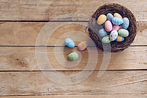 Colorful Easter egg and nest on wooden table background with copy space