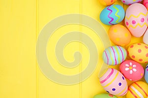 Colorful Easter Egg side border over a yellow wood background