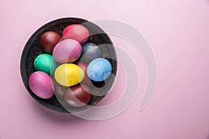 Colorful Easter eggs as an attribute of Easter celebration on the plate. Top view