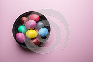 Colorful Easter eggs as an attribute of Easter celebration on the plate. Top view