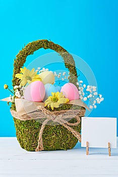 Colorful easter eggs in backet on a blue background