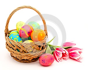 Colorful easter eggs in basket and flowers