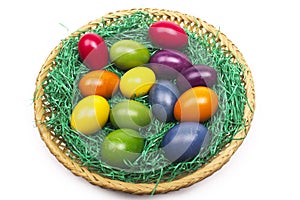 Colorful Easter eggs in a basket on the gras