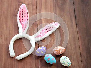 Colorful Easter eggs with bunny rabbit ears hat on wooden background festival and holiday spring coming Easter calibration