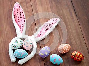 Colorful Easter eggs with bunny rabbit ears hat on wooden background  festival and holiday spring coming  Easter calibration