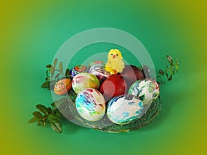 Colorful Easter eggs and chick in plate