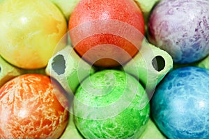 Colorful easter eggs in a egg carton box close up