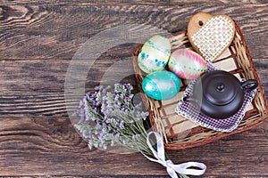 Colorful Easter Eggs with flowers and tea pot on wood