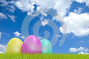 Colorful easter eggs in front of a cloudy sky with