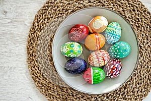 Colorful Easter eggs hand-painted at home. Using food coloring to dye Easter eggs. Painting eggs with candle wax. Getting ready