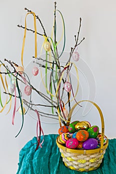 Colorful easter eggs hanging on branch.