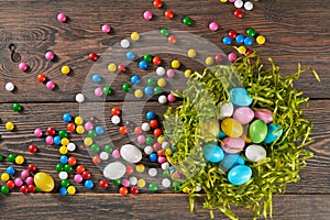 Colorful easter eggs in nest and candies.