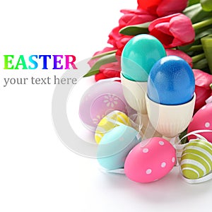 Colorful easter eggs and pink tulips over white with sample text