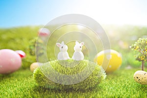 Colorful easter eggs and rabbits toy on fresh spring grass in the garden. Close up of easter bunny