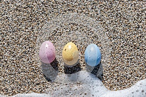 Colorful Easter eggs on the seaside in sunny day.