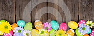 Colorful Easter eggs and spring flowers bottom border against a dark wood banner background
