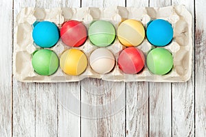 Colorful easter eggs in a tray over wooden background. Space for text. Easter card.