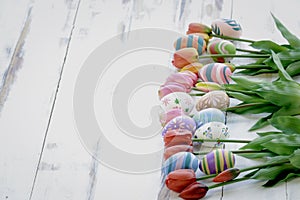 Colorful Easter eggs with tulip flowers on wooden background  festival and holiday spring coming  Easter calibration