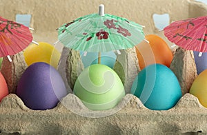 Colorful Easter eggs under umbrellas in a box