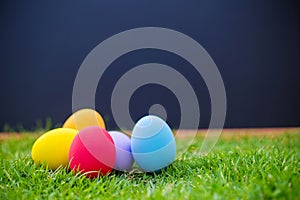 colorful easter eggs under white mushroom on the green garden yard. symbol of easter`s day festival.