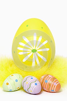 Colorful Easter Eggs and Yellow Feathers on White Background