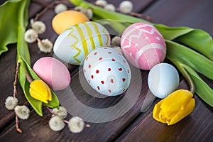 Colorful Easter eggs with yellow Tulip hand painted on a dark wooden background. Holiday spring card