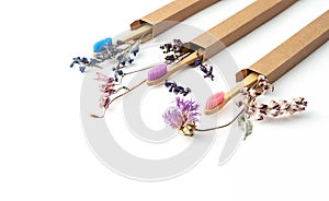 Colorful eco friendly bamboo toothbrushes with dried flowers. Zero wast wooden toothbrushes personal dental care accessories.