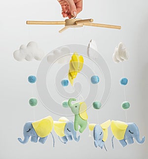 Colorful and eco-friendly children`s mobile from felt for children. On grey background