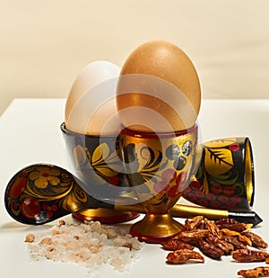 Colorful eggcups with eggs, spoon, salt and chili
