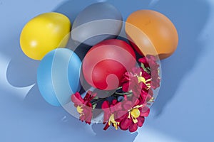 Colorful eggs, symbolizing Easter, on a colorful background and flowers