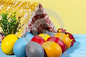 Colorful eggs symbolizing easter, with a toy house, flowers like a garden