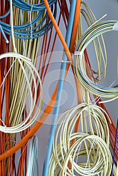 Colorful electrical cables hanging from the ceiling in spirals and bundles