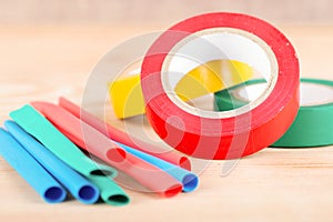 colorful electrical insulating tape and heat shrink tubing wooden background
