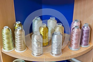 Colorful embroidery thread spool using in garment industry, row of multicolored yarn rolls, sewing material selling in the market