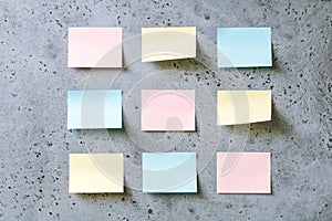 Colorful empty sticky notes on a grey textured background