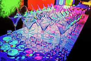 Colorful empty wine glasses overlap on the bar counter at the nightclub party