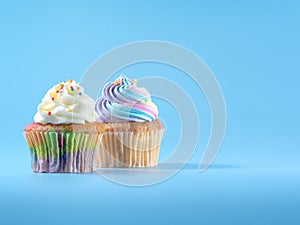 Colorful and enteresting cupcake isolated on blue background studio close up shot.