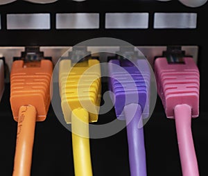 Colorful ethernet cables connected in a row into patch panel.