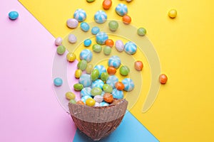 Colorful explosion of sweets in a coconut on bright multi-colored backgrounds, creative still life