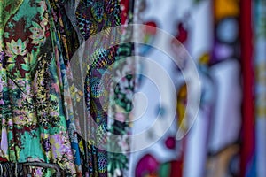 Colorful fabrics hanging and lined. Fabrics with different patterns and colored rows.