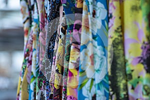 Colorful fabrics hanging and lined. Fabrics with different patterns and colored rows.