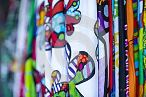 Colorful fabrics hanging and lined. Fabrics with different patterns and colored rows.