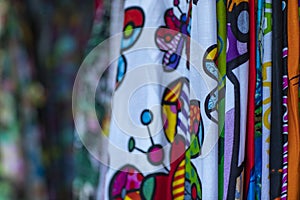 Colorful fabrics hanging and lined. Fabrics with different patterns and colored rows.