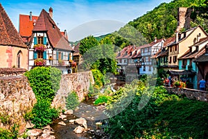 Colorful facades and flowers overlooking the river in the village of Kaisersberg in Alsace, France