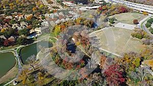 Colorful fall foliage at Park Central with luxury lakeside residential houses, soccer fields, White Rock Creek near major highways