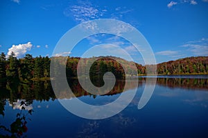 Colorful Fall Leaf Foliage on a Lakeside retreat in the Adirondack Mountains. Vibrant red, yellow, and orange colors of autumn.