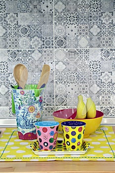 Colorful fancy cup and fancy utensil on yellow polka dot napery