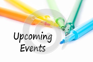 Colorful felt-tip pen and Upcoming Event word on white background.